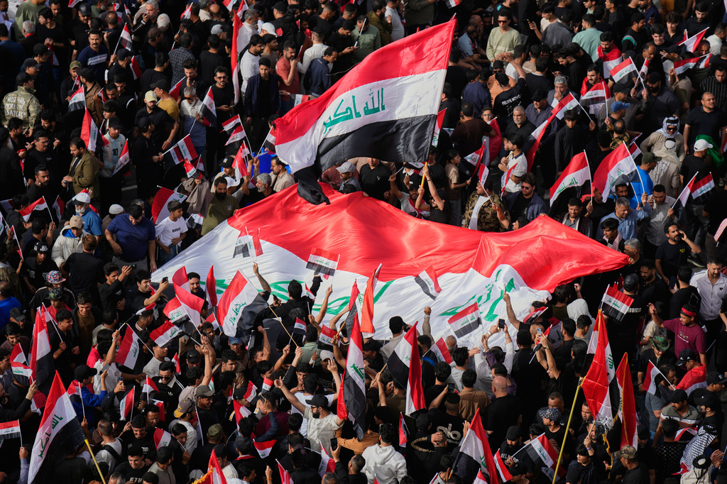 Followers of Iraq's Shiite cleric Muqtada al-Sadr chant slogans as they wave national Iraqi flag during a protest against U.S. and Israeli attacks on multiple cities across Iran, in Tahrir Square, Baghdad, Baghdad, Iraq, Saturday, April 4, 2026. (AP Photo/Hadi Mizban)