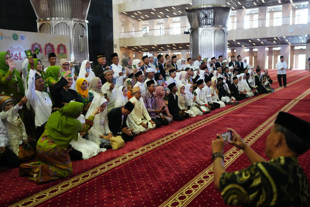 Brides and grooms prepare for a group photo after a mass wedding ceremony at Istiqlal Mosque in Jakarta, Indonesia, Wednesday, Dec. 3, 2025. (AP Photo/Tatan Syuflana)