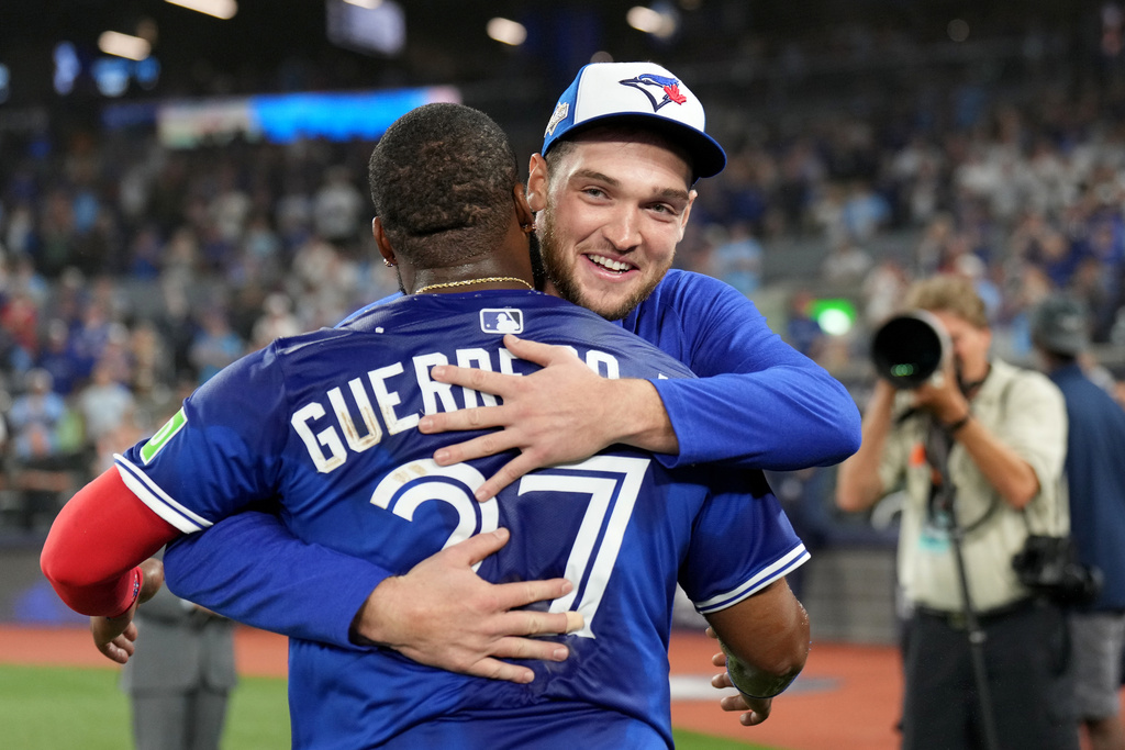 Toronto Blue Jays pitcher Trey Yesavage, right, and teammate Vladimir Guerrero Jr. (27) celebrate following their team's win over the New York Yankees in Game 2 of baseball's American League Division Series in Toronto, Sunday, Oct. 5, 2025. (Nathan Denette/The Canadian Press via AP)