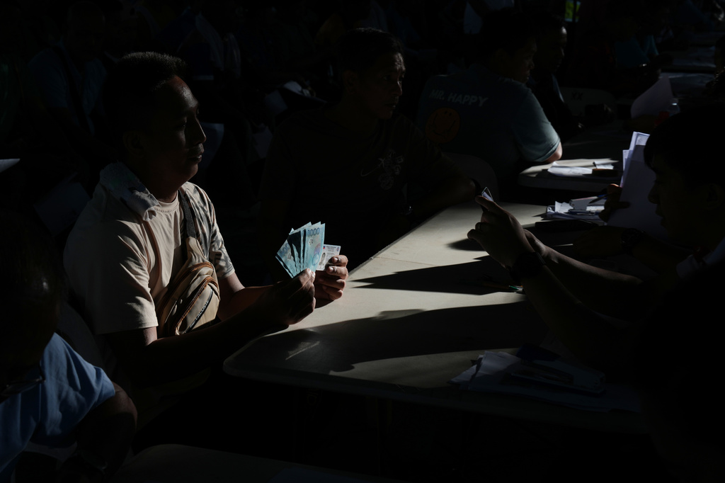 FILE - A jeepney driver poses after receiving cash assistance from the government to help in their livelihood as oil prices continue to rise, Wednesday, March 25, 2026, in Quezon city, Philippines. (AP Photo/Aaron Favila, file)