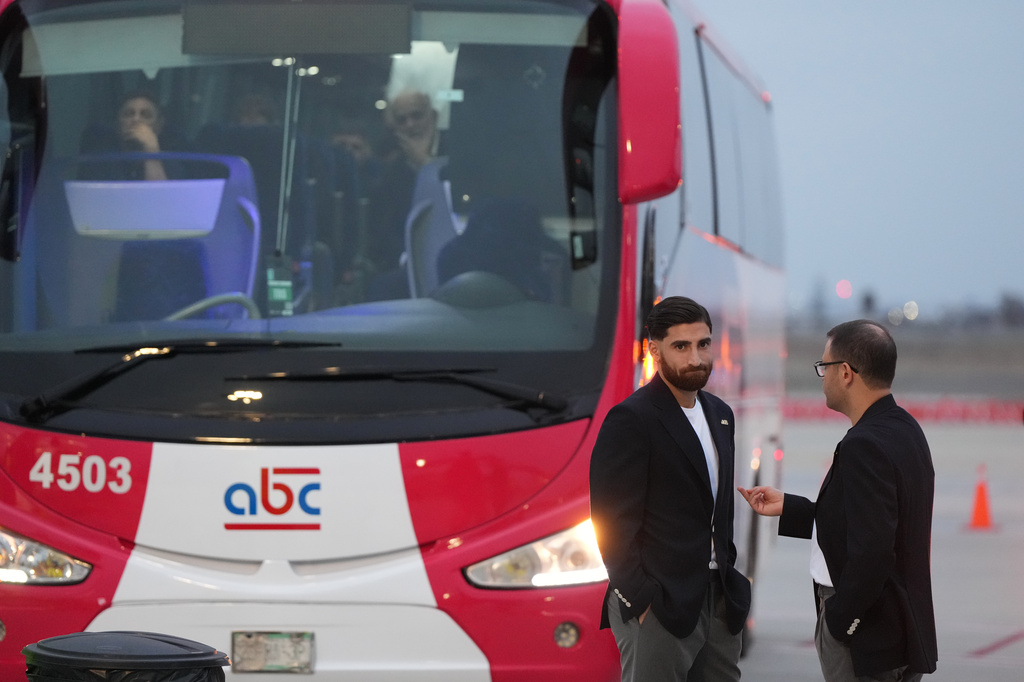Iran's Alireza Jahanbakhsh, second from right, talks with a team official as he arrives with his teammates for the World Cup soccer tournament in Tijuana, Mexico, Sunday, June 7, 2026. (AP Photo/Gregory Bull)