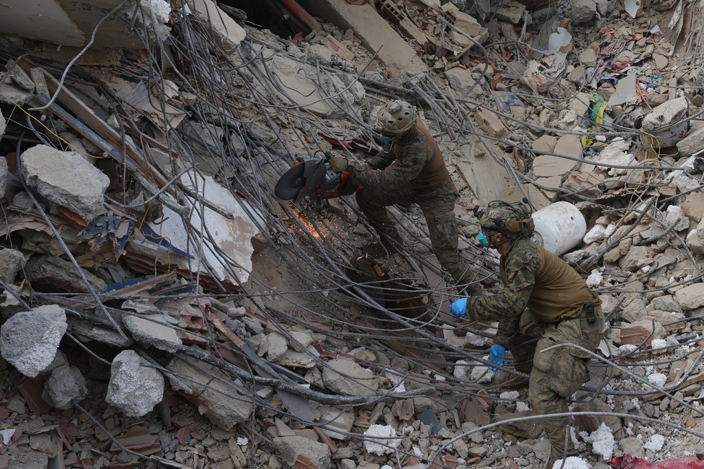 U.S. troops cut through rebar while clearing rubble during a search at a building that collapsed in the twin earthquakes in La Guaira, Venezuela, Tuesday, June 30, 2026. (AP Photo/Ariana Cubillos)
