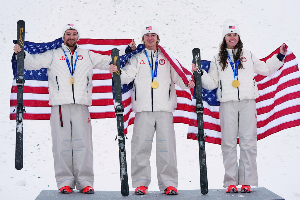 Gold medalists United States' Christopher Lillis, Connor Curran and Kaila Kuhn celebrate after the freestyle skiing mixed team aerials final at the 2026 Winter Olympics, in Livigno, Italy, Saturday, Feb. 21, 2026. (AP Photo/Gregory Bull)