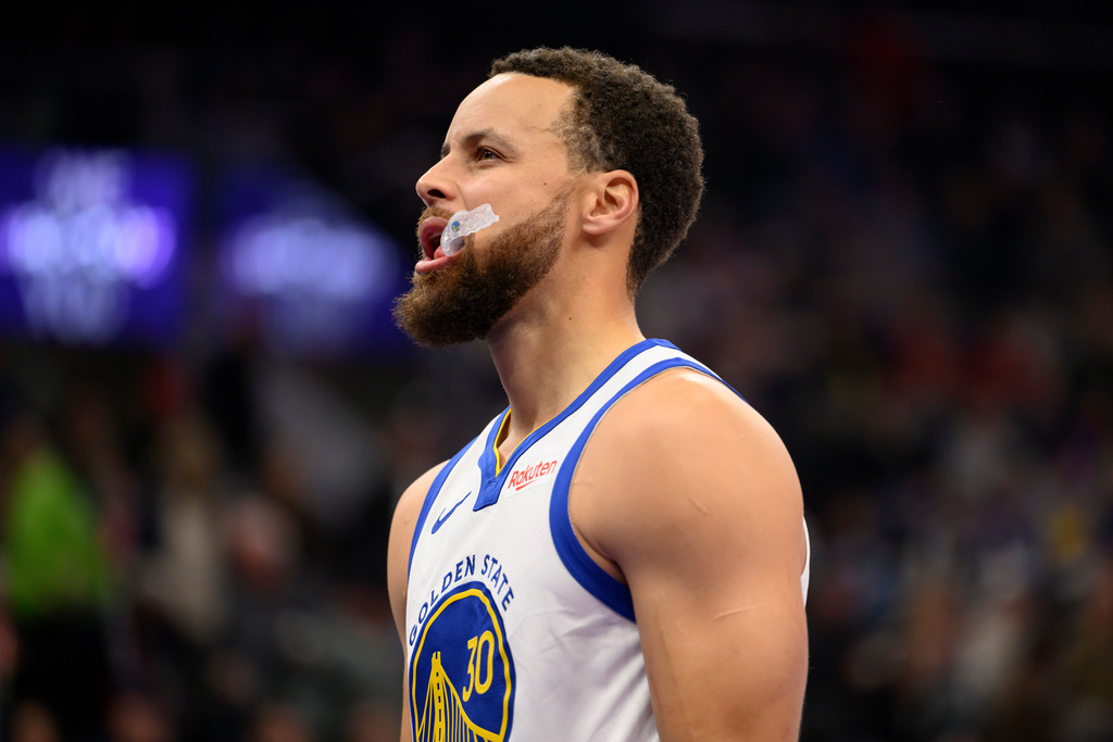 Golden State Warriors guard Stephen Curry reacts to making a 3-point shot during the first half of an NBA basketball game against the Utah Jazz, Wednesday, Jan. 28, 2026, in Salt Lake City. (AP Photo/Tyler Tate)