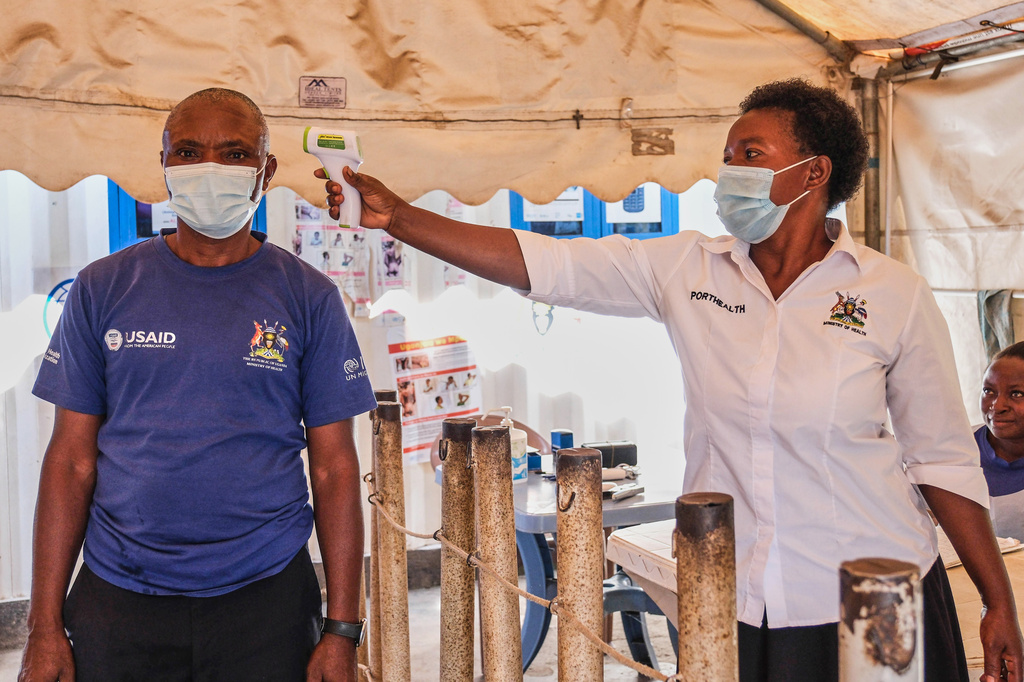 FILE - A health worker checks an individual's temperature at a temporary health clinic at the Mpondwe border crossing linking Uganda and the Democratic Republic of the Congo, Thursday, June 4, 2026. (AP Photo/Hajarah Nalwadda, File)