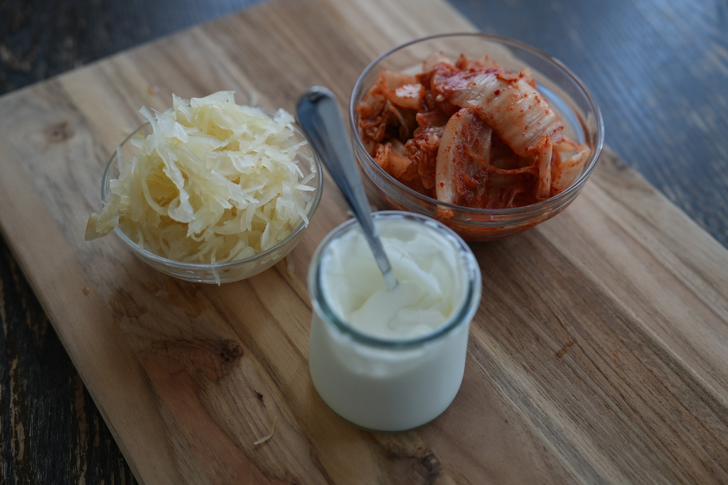 Kimchi, sauerkraut and yogurt are displayed on a kitchen table in New York on July 10, 2026. (AP Photo/Mary Conlon)