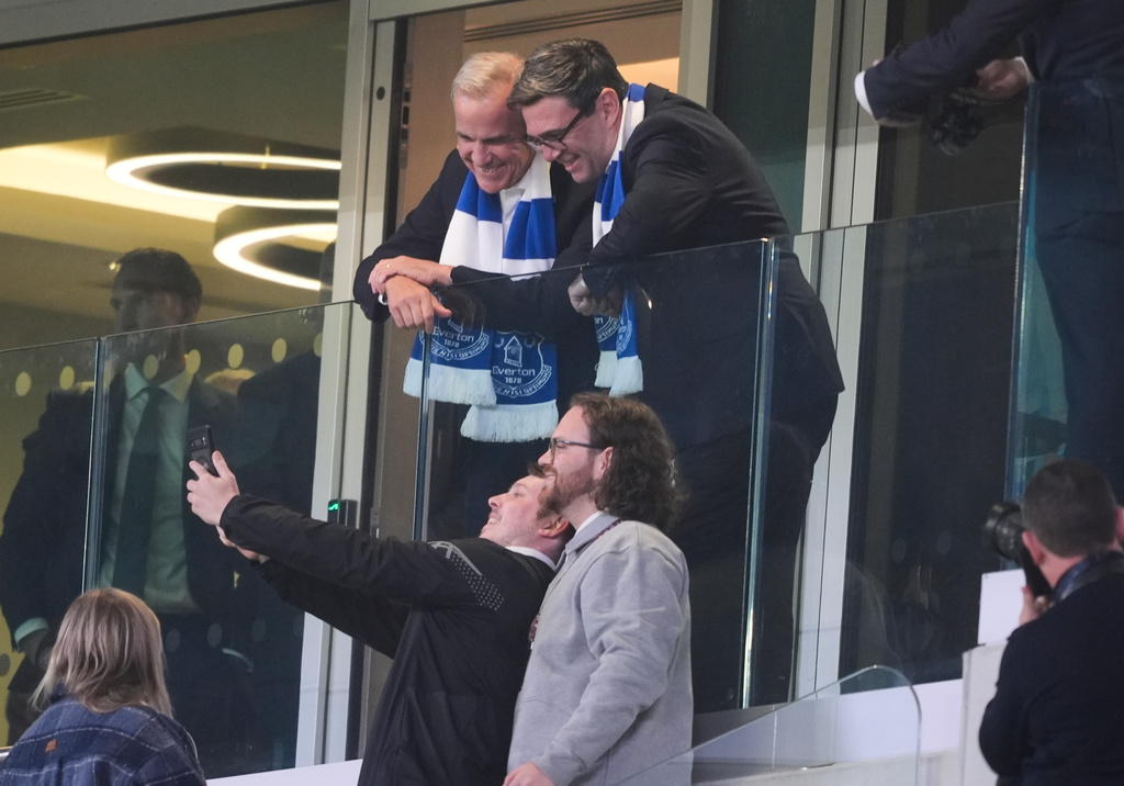 Britain's Prime Minister Andy Burnham, top right, and Canada's Prime Minister Mark Carney pose for a selfie before the League Cup third round round soccer match between Everton and Wolverhampton Wanderers, Wednesday, Sept. 16, 2026, in Liverpool, England. (Peter Byrne/PA via AP)