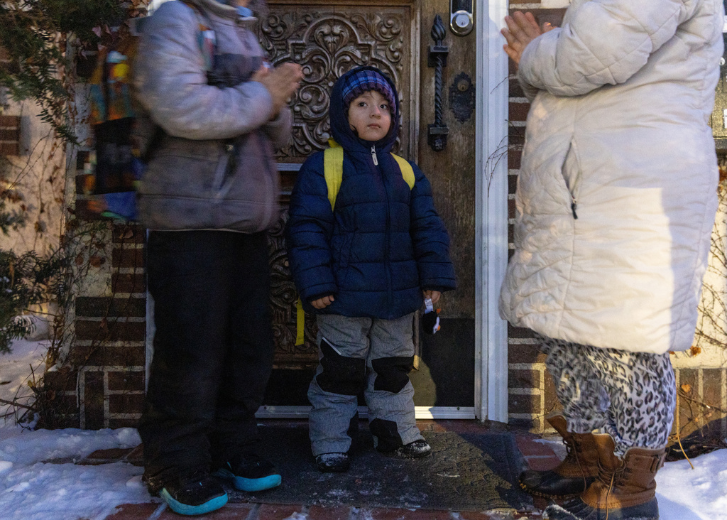 Giancarlo, 10, left, and Yair, 3, pray with their mom, right, before Giancarlo is picked up for school Tuesday, Feb. 3, 2026, in Minneapolis. (AP Photo/Liam James Doyle)