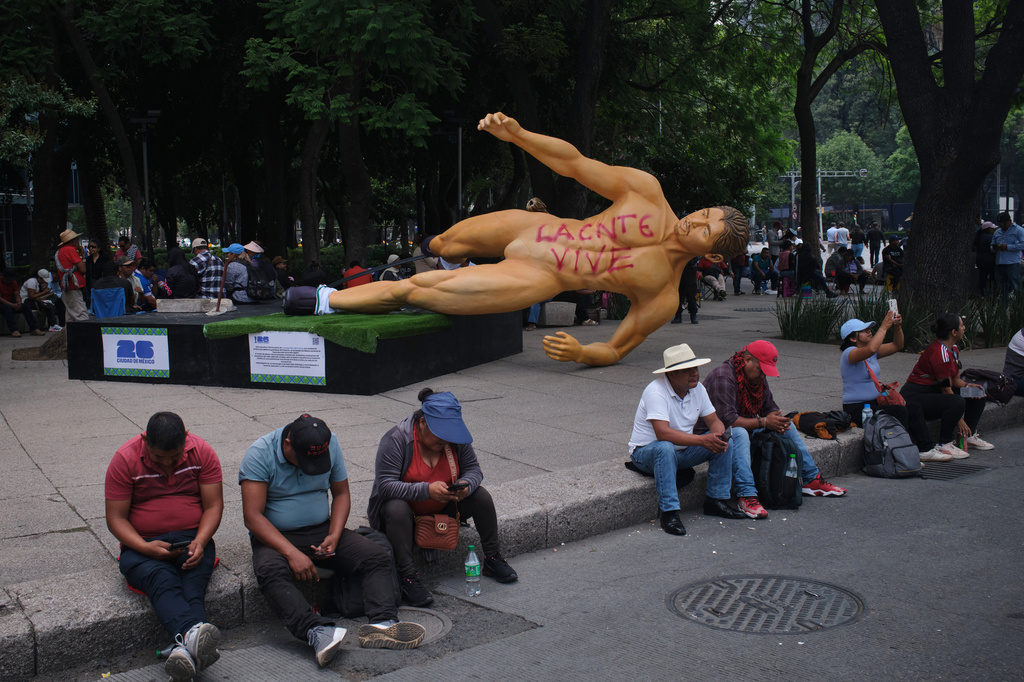A World Cup statue, with graffiti that reads in Spanish, "The National Educational Workers Coordination lives" lies sideways during a teachers' protest for higher salaries sit in Mexico City, Tuesday, June 2, 2026. (AP Photo/Jon Orbach)