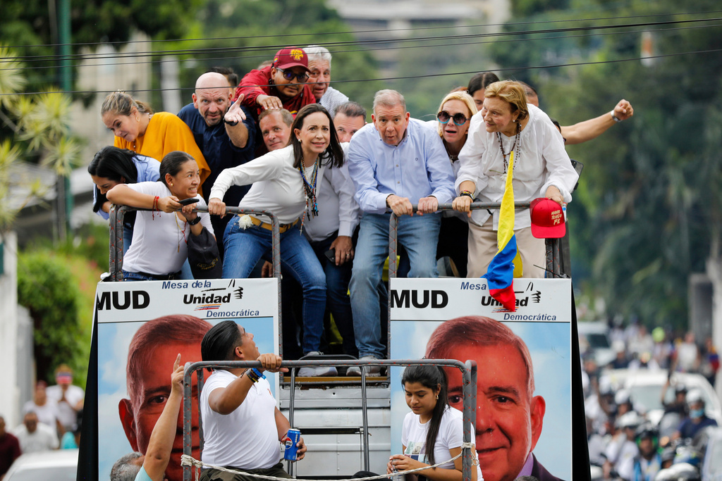 FILE - Opposition leader Maria Corina Machado, center left, and opposition candidate Edmundo Gonzalez bend down to avoid cables as they ride on the top of a truck during a protest against official presidential election results declaring President Nicolas Maduro the winner in Caracas, Venezuela, Tuesday, July 30, 2024, two days after the vote. (AP Photo/Cristian Hernandez, File)