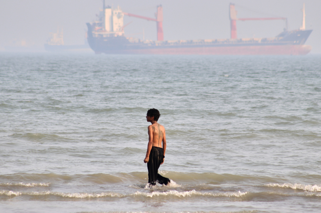A boy walks on shallow water as commercial vessels are anchored in the Strait of Hormuz off Bandar Abbas, Iran, Monday, Aug. 31, 2026. (Razieh Poudat/ISNA via AP)