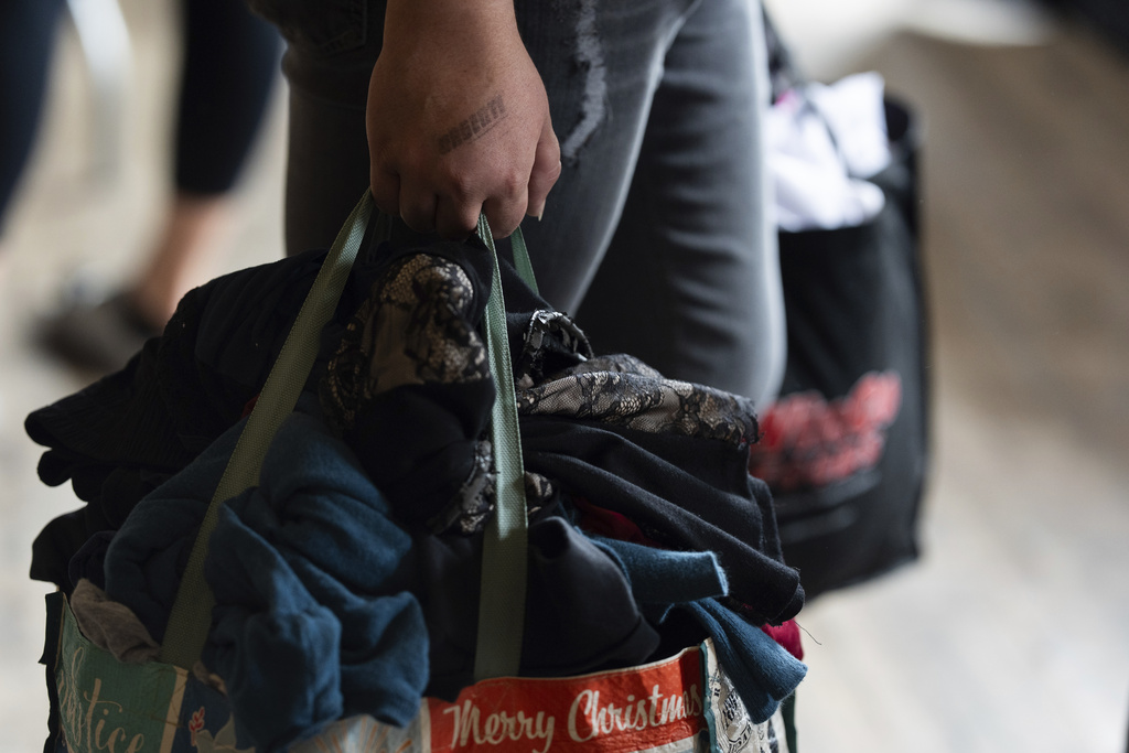 Micailyn Williams holds bags filled with clothing she selected during a clothing swap on Sunday, Sept. 14, 2025, in Portland, Ore. (AP Photo/Jenny Kane)