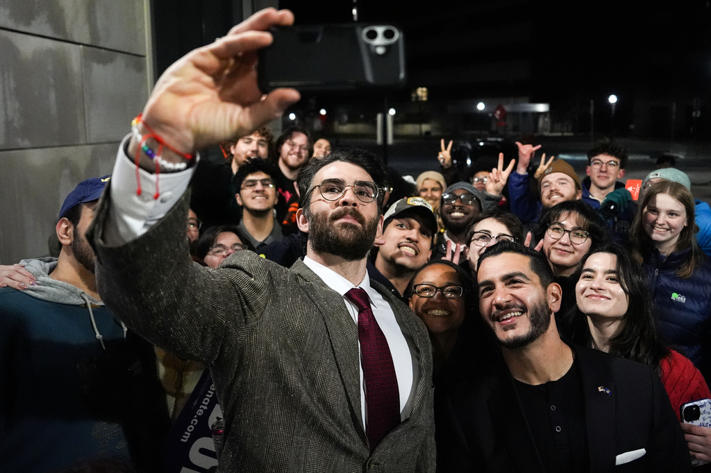 Streamer Hasan Piker, left, and Abdul El-Sayed, a progressive candidate in the Democratic primary for U.S. Senate in Michigan, center right, take a selfie with young fans following a campaign event, Tuesday, April 7, 2026, at the University of Michigan in Ann Arbor, Mich. (AP Photo/Julia Demaree Nikhinson)
