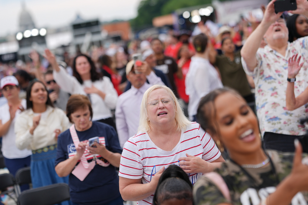 People worship to Christian music at Rededicate 250, a mostly conservative Christian prayer gathering in honor of the United States' 250th anniversary, on the National Mall, Sunday, May 17, 2026, in Washington. (AP Photo/Julia Demaree Nikhinson)