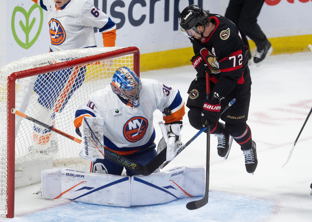 New York Islanders goaltender Ilya Sorokin (30) makes a save as he is screened by Ottawa Senators' Thomas Chabot (72) during third period NHL action in Ottawa, Thursday, March 19, 2026. (Adrian Wyld/The Canadian Press via AP)
