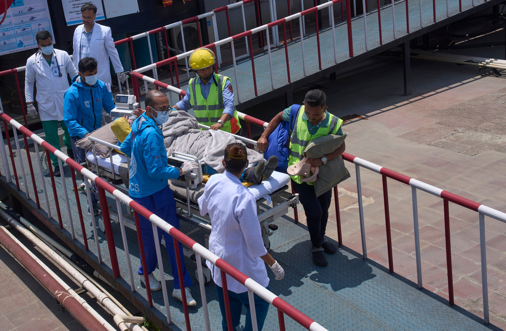 Medics take Dawa Sherpa, a mountain guide who had been missing for several days in the Everest region, for treatment after he arrived at HAMS Hospital in Kathmandu, Nepal, Thursday, June 4, 2026. (AP Photo/Niranjan Shrestha) CORRECTION: Corrects hospital name to HAMS not Grande
