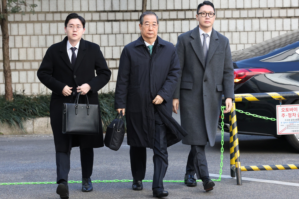 Former South Korean Prime Minister Han Duck-soo, center, arrives at the Seoul Central District Court for his first sentencing trial in the insurrection case, in Seoul Wednesday, Jan. 21, 2026. (Chung Sung-Jun/Pool Photo via AP)