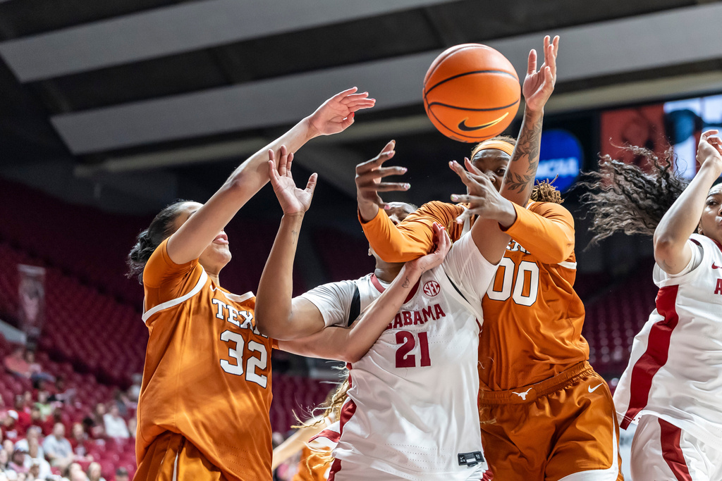 Texas forward Teya Sidberry (32) and center Kyla Oldacre (00) battle for a rebound against Alabama forward Essence Cody (21) during the first half of an NCAA college basketball game Sunday, March 1, 2026, in Tuscaloosa, Ala. (AP Photo/Vasha Hunt)