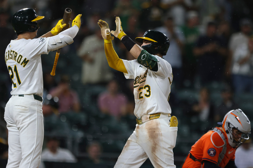 Athletics' Shea Langeliers (23) celebrates his solo home with Tyler Soderstrom, left, during the seventh inning of a baseball game against the Houston Astros, Wednesday, Sept. 24, 2025, in West Sacramento, Calif. (AP Photo/Scott Marshall)
