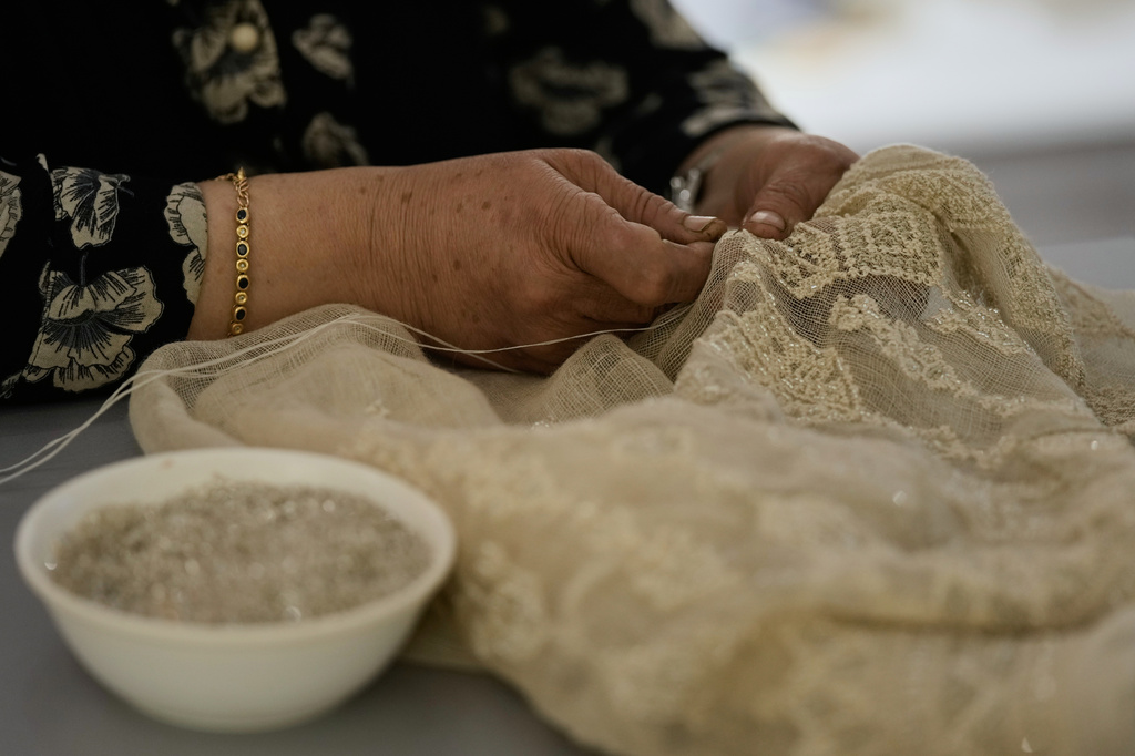 Palestinian weaver Samira Nasser works on a handmade embroidered piece at the Inaash Association embroidery workshop in Beirut, Tuesday, May 19, 2026. (AP Photo/Bilal Hussein)
