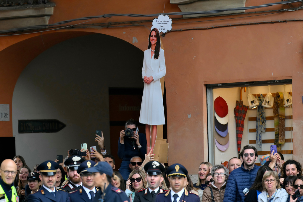 A placard of Britain's Kate, Princess of Wales, is seen through the crowd waiting outside the town hall, where the Princess of Wales is visiting as part of a two-day trip, in Reggio Emilia, Italy, Wednesday, May 13, 2026. (Marco Bertorello/Pool Photo via AP)