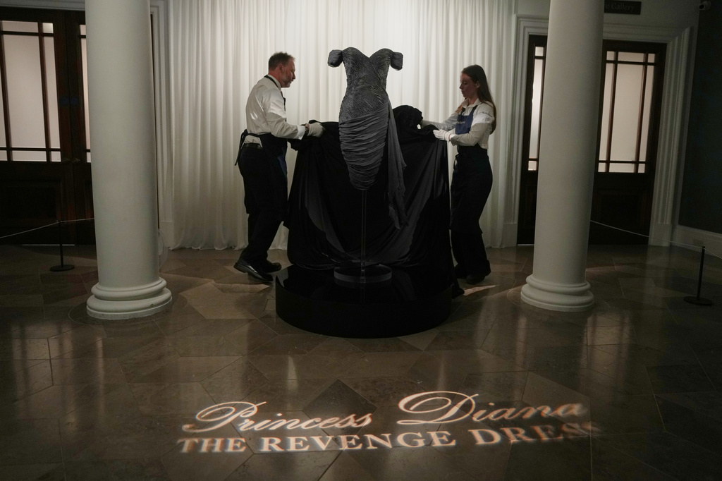 A dress worn by the late Princess Diana and known as the ''Revenge Dress'', designed by Christina Stambolian, is unveiled by staff at Sotheby’s auction house in London, Friday, Sept. 18, 2026, ahead of its Dec. 9 auction in New York, where it is estimated to sell for US$150,000-300,000. (AP Photo/Alastair Grant)