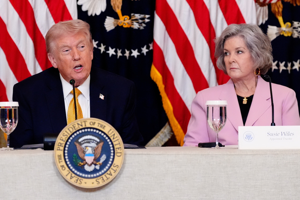 President Donald Trump speaks during a board meeting of the John F. Kennedy Memorial Center For The Performing Arts in the East Room of the White House, Monday, March 16, 2026, in Washington, as White House Chief of Staff Susie Wiles, looks on. (AP Photo/Alex Brandon)