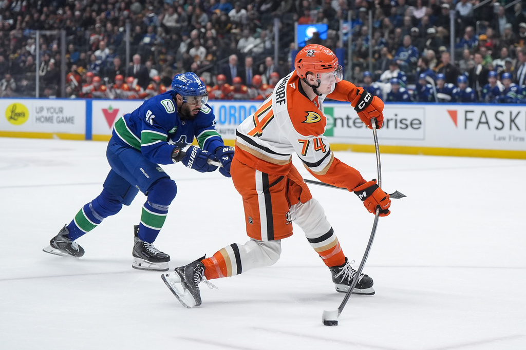 Anaheim Ducks' Ian Moore (74) takes a shot on goal while being checked by Vancouver Canucks' Evander Kane (91) during the first period of an NHL hockey game, in Vancouver, on Thursday, Jan. 29, 2026. (Darryl Dyck/The Canadian Press via AP)
