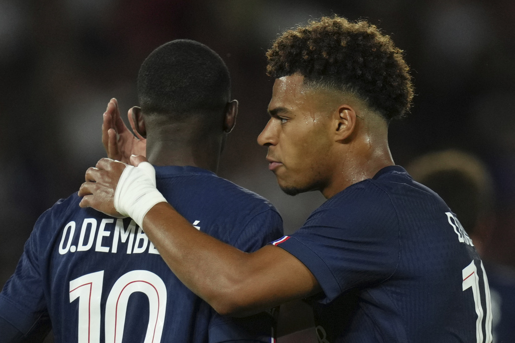 PSG's Desire Doue, right, talks to PSG's Ousmane Dembele during the League One soccer match Paris Saint-Germain against Angers at the Parc des Princes stadium, Friday, Aug. 22, 2025 in Paris. (AP Photo/Aurelien Morissard)