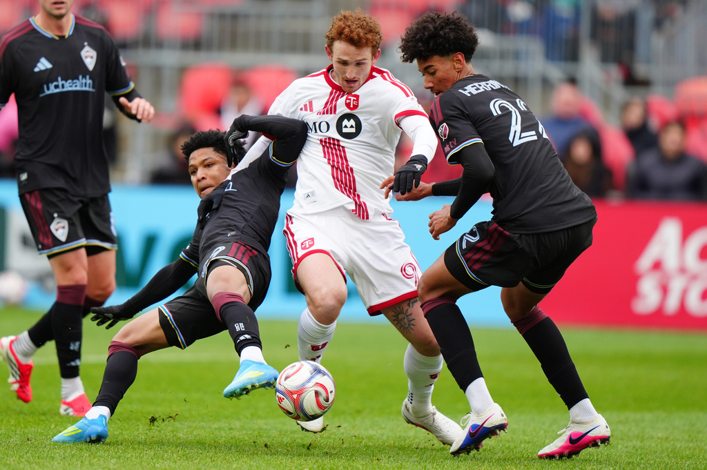 Toronto FC forward Josh Sargent, center, moves with the ball between Colorado Rapids defenders Jackson Travis, left, and Lucas Herrington (22) during the first half of an MLS soccer game in Toronto, Saturday, April 4, 2026. (Frank Gunn/The Canadian Press via AP)