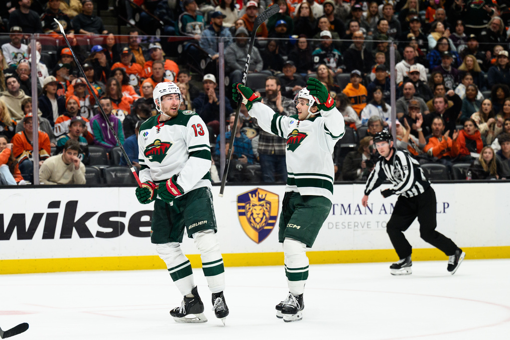 Minnesota Wild center Yakov Trenin (13) is greeted by Minnesota Wild defenseman Brock Faber after scoring during the second period of an NHL hockey game against the Anaheim Ducks, Friday, Jan. 2, 2026, in Anaheim, Calif. (AP Photo/William Liang)
