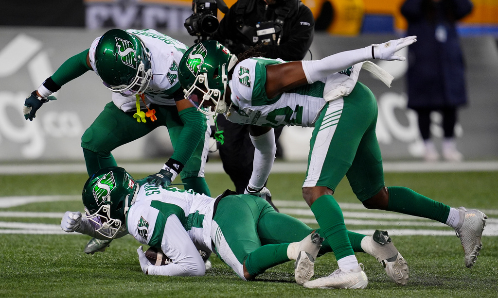 Saskatchewan Roughriders' Marcus Sayles (8), bottom, celebrates with teammates after recovering a fumble from Montreal Alouettes' Shea Patterson (7) during second half CFL football action in the Grey Cup in Winnipeg, Manitoba, Sunday, Nov. 16, 2025. (Frank Gunn/The Canadian Press via AP)