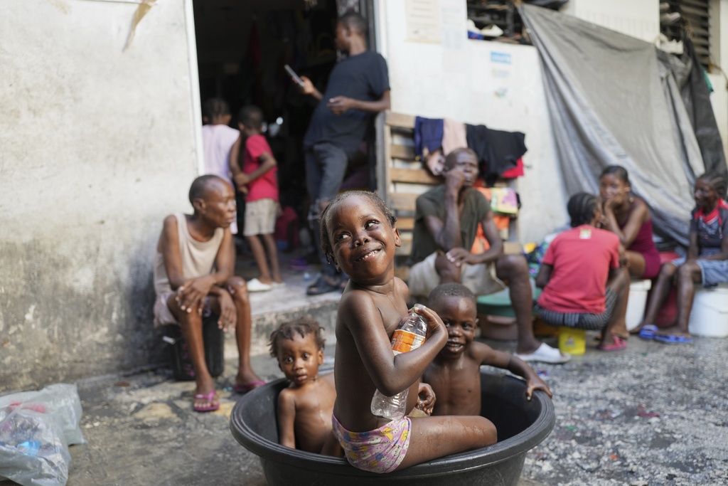 Children bathe at a makeshift shelter for people displaced by gang violence in Port-au-Prince, Haiti, Wednesday, Sept. 17, 2025. (AP Photo/Odelyn Joseph)