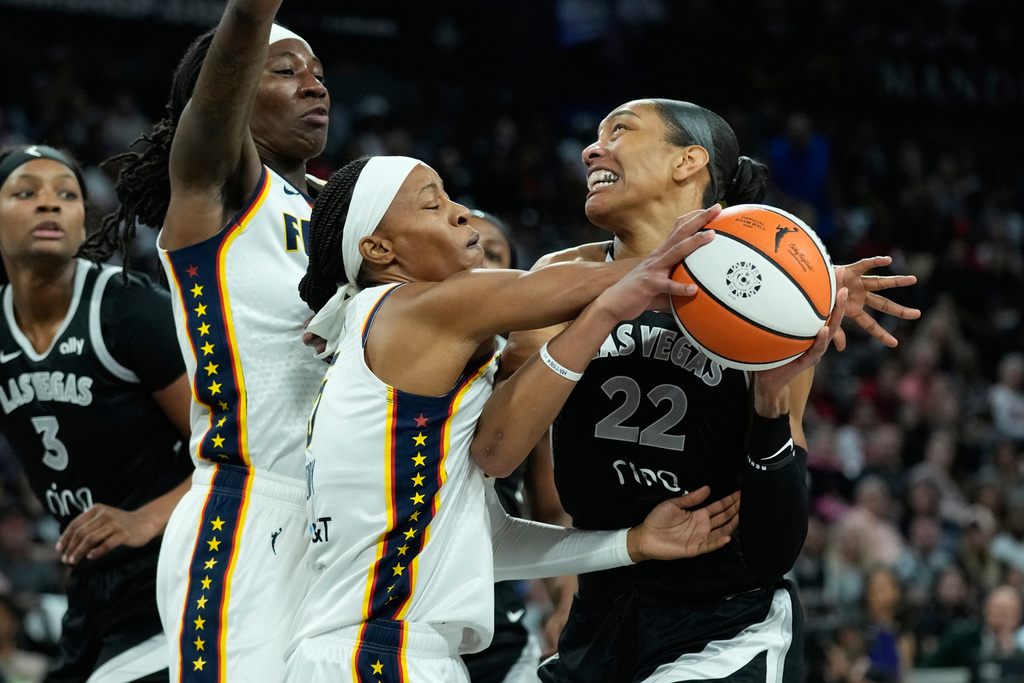 Indiana Fever guard Shey Peddy (5) fouls Las Vegas Aces center A'ja Wilson (22) during the first half of Game 5 of a WNBA basketball playoff semifinals series Tuesday, Sept. 30, 2025, in Las Vegas. (AP Photo/John Locher)