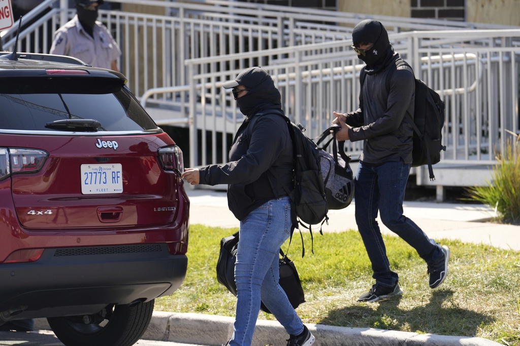 Masked people leave an immigration processing center Monday, Sept. 8, 2025, in Broadview, Ill., a suburb of Chicago. (AP Photo/Carolyn Kaster)