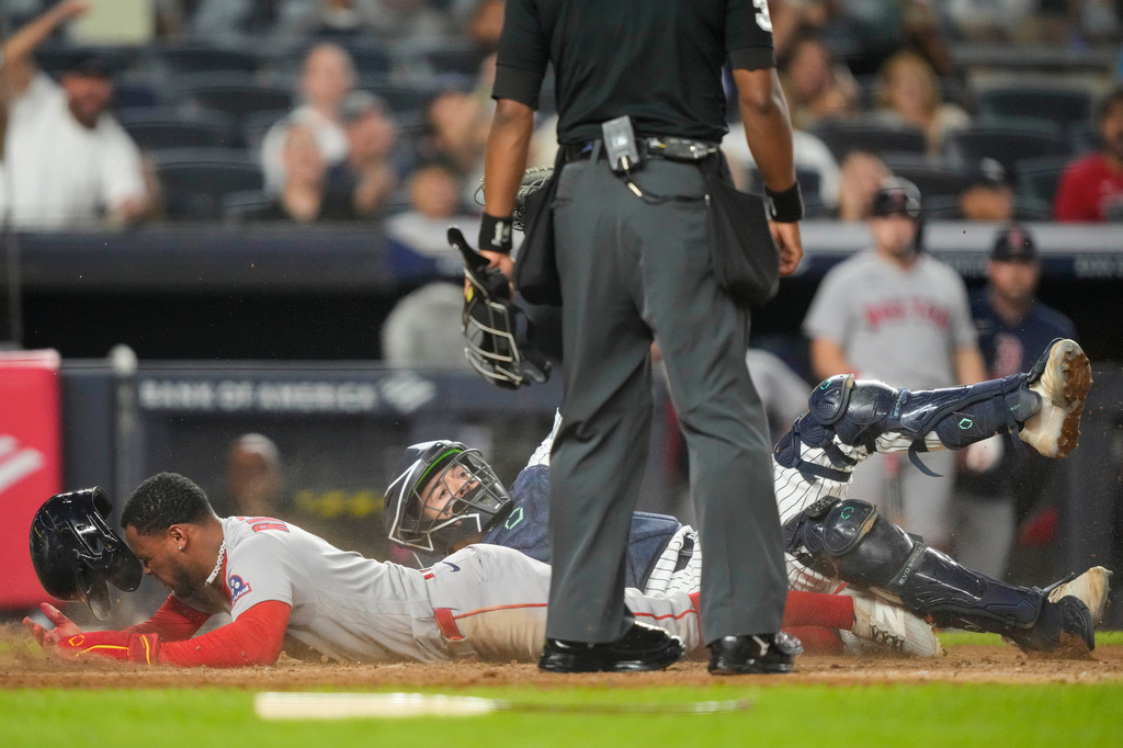Boston Red Sox' Ceddanne Rafaela is tagged out by New York Yankees catcher Austin Wells at home plate on a double play during the seventh inning of a baseball game, Friday, Aug. 28, 2026, in New York. (AP Photo/Yuki Iwamura)