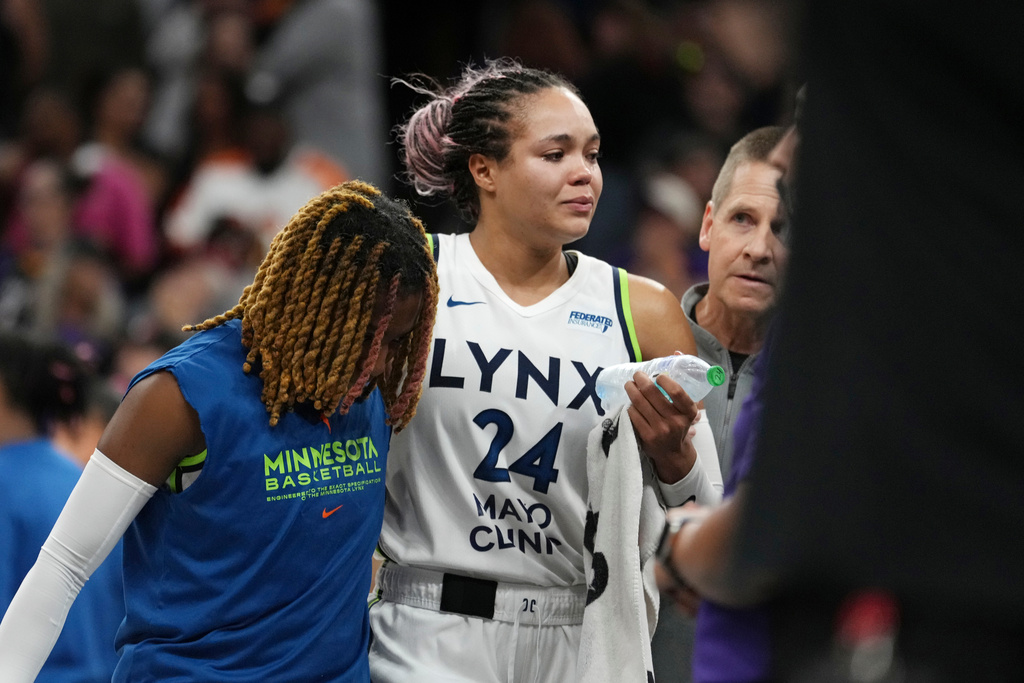 An injured Minnesota Lynx forward Napheesa Collier is helped off the court during the second half of Game 3 of a WNBA basketball playoff semifinals series game against the Phoenix Mercury Friday, Sept. 26, 2025, in Phoenix. (AP Photo/Ross D. Franklin)