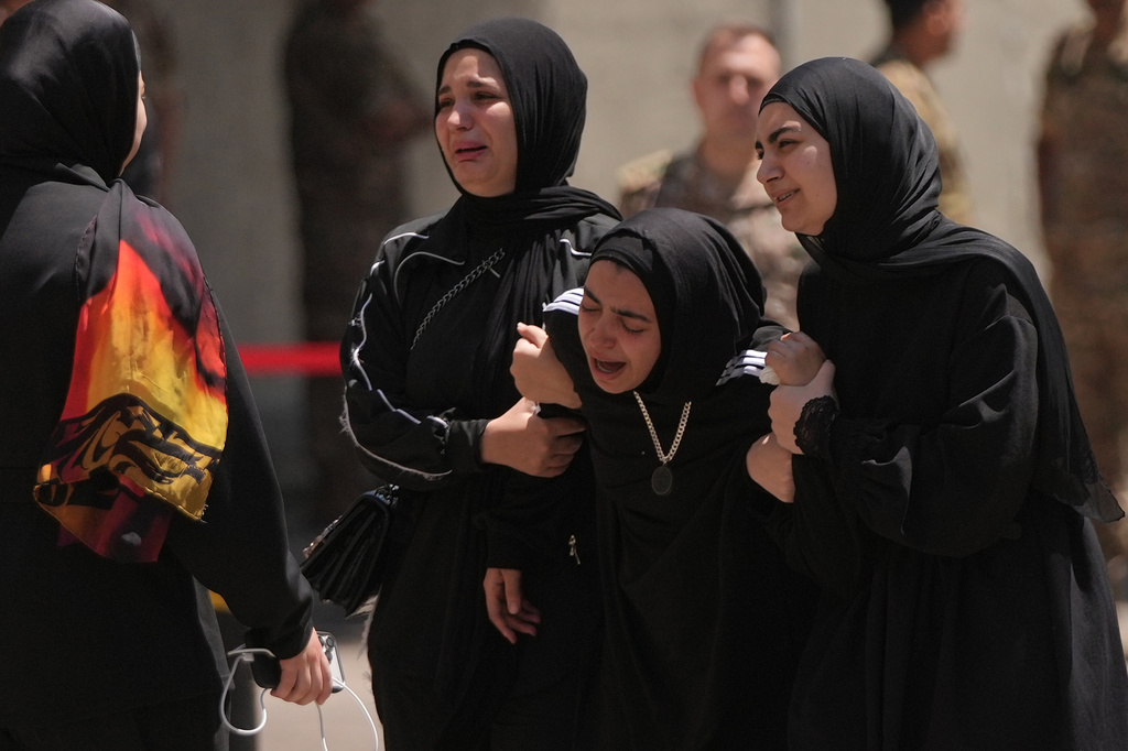 Relatives of the Lebanese soldier Hussein Nazzal, who was killed Saturday in south Lebanon along with a brigadier general and a captain in an Israeli airstrike, mourn during his funeral procession in Beirut, Sunday, June 7, 2026. (AP Photo/Hassan Ammar)