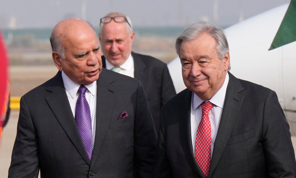 Iraqi Foreign Minister Fouad Hussein, left, greets United Nations Secretary-General Antonio Guterres, right, at Baghdad airport, Iraq, Saturday, Dec.13, 2025. (AP Photo/Hadi Mizban)