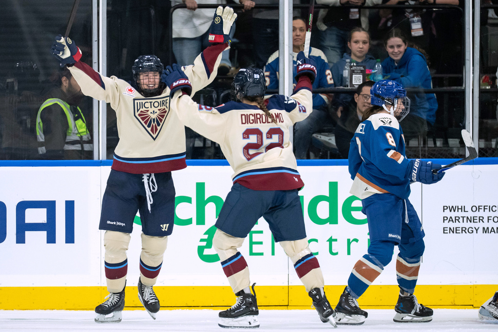 Montreal Victoire's Shiann Darkangelo celebrates her goal against the Vancouver Goldeneyes with Jessica Digirolamo (22) as Vancouver Goldeneyes' Izzy Daniel (8) skates away during the third period of a PWHL hockey game in Vancouver, British Columbia, Saturday, Dec. 20, 2025. (Ethan Cairns/The Canadian Press via AP)