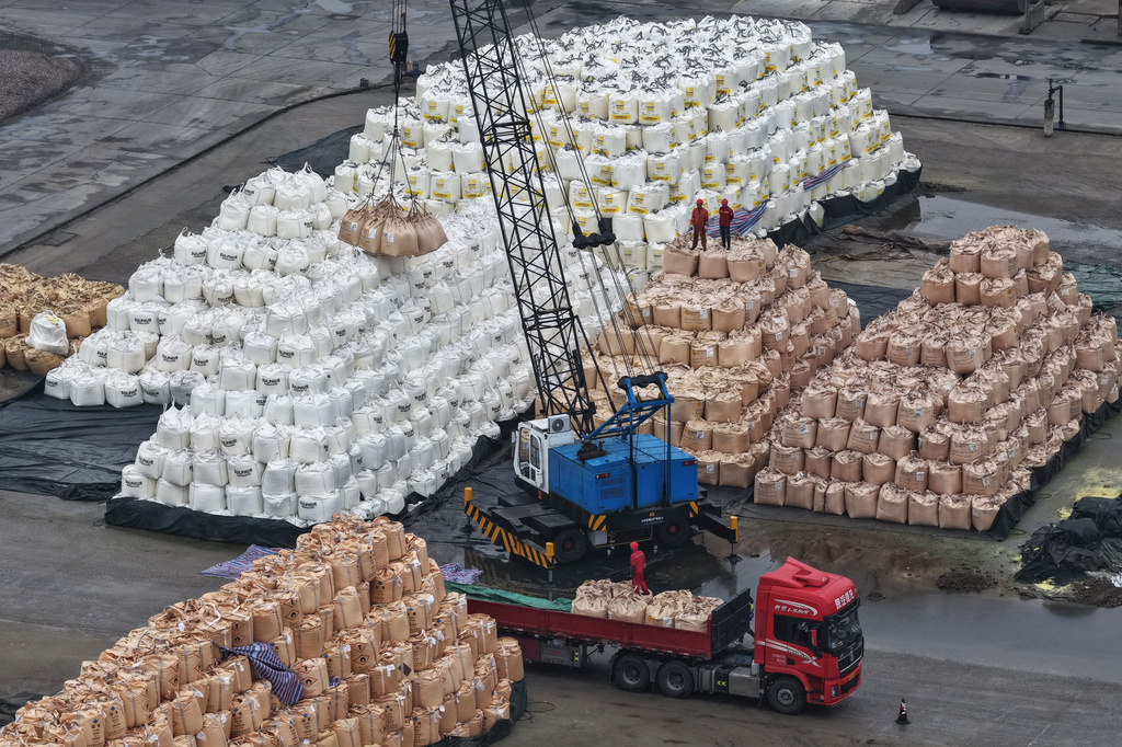 Workers transfer bags of imported solid sulfur onto a truck in a port in Nanjing in eastern China's Jiangsu province, Tuesday, April 14, 2026. (Chinatopix Via AP) CHINA OUT
