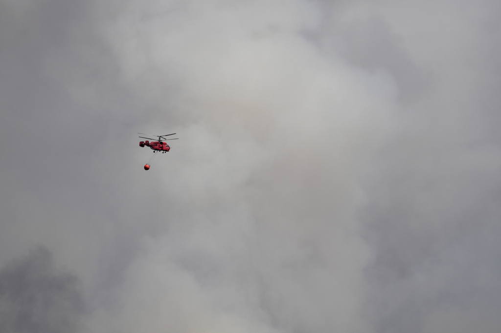 A firefighter's helicopter battles a forest fire in Deliblatska Pescara (Deliblato Sands), near the village of Sumarak, 70 kilometers north-west of Belgrade, Serbia, Thursday, Aug. 20, 2026. (AP Photo/Darko Vojinovic)
