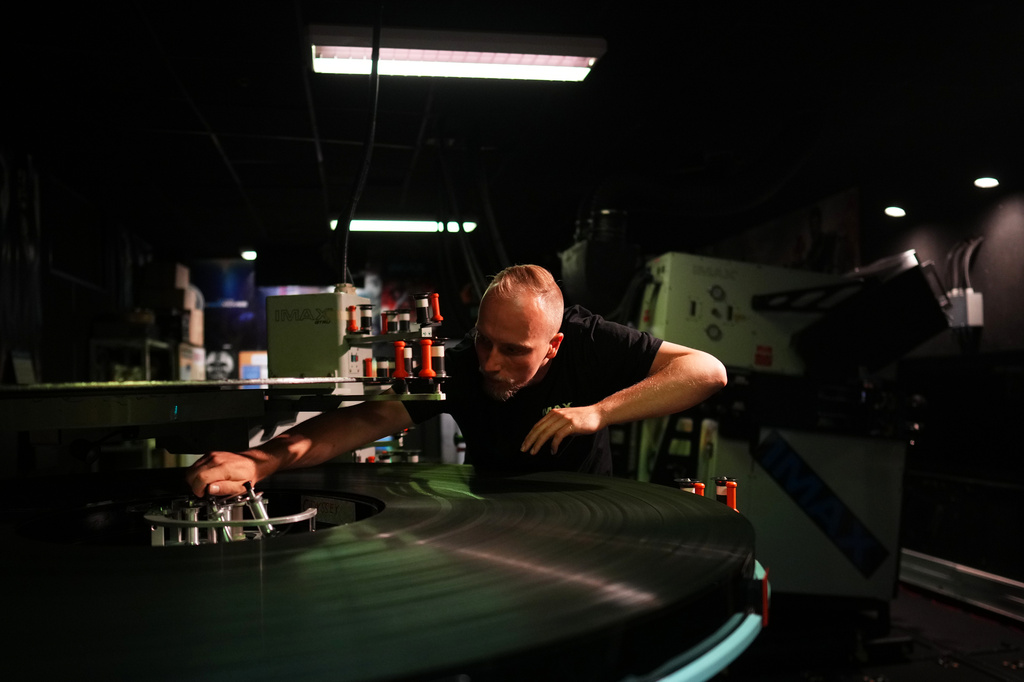 Tomas Vysinsky prepares the 70 mm IMAX copy of Christopher Nolan's "The Odyssey" for screening in Prague, Czech Republic, Monday, July 27, 2026. (AP Photo/Petr David Josek)