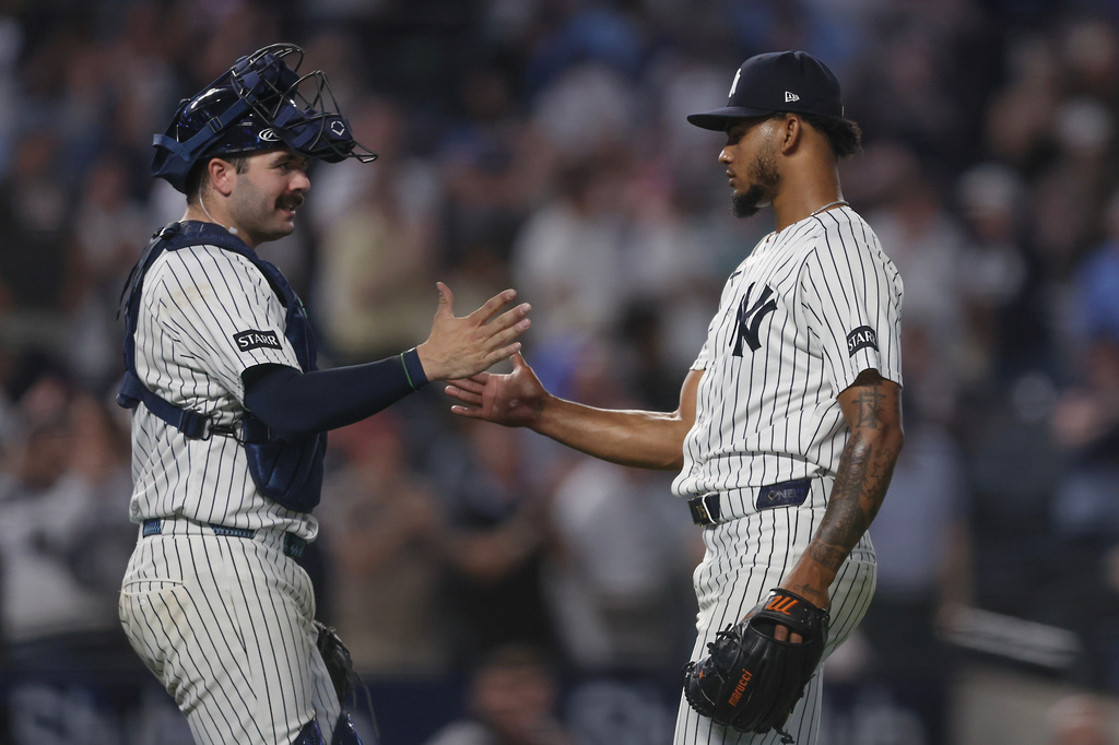 New York Yankees catcher Austin Wells, left, and pitcher Camilo Doval, right, shake hands after a win over the Toronto Blue Jays in a baseball game, Tuesday, May 19, 2026, in New York. (AP Photo/Heather Khalifa)