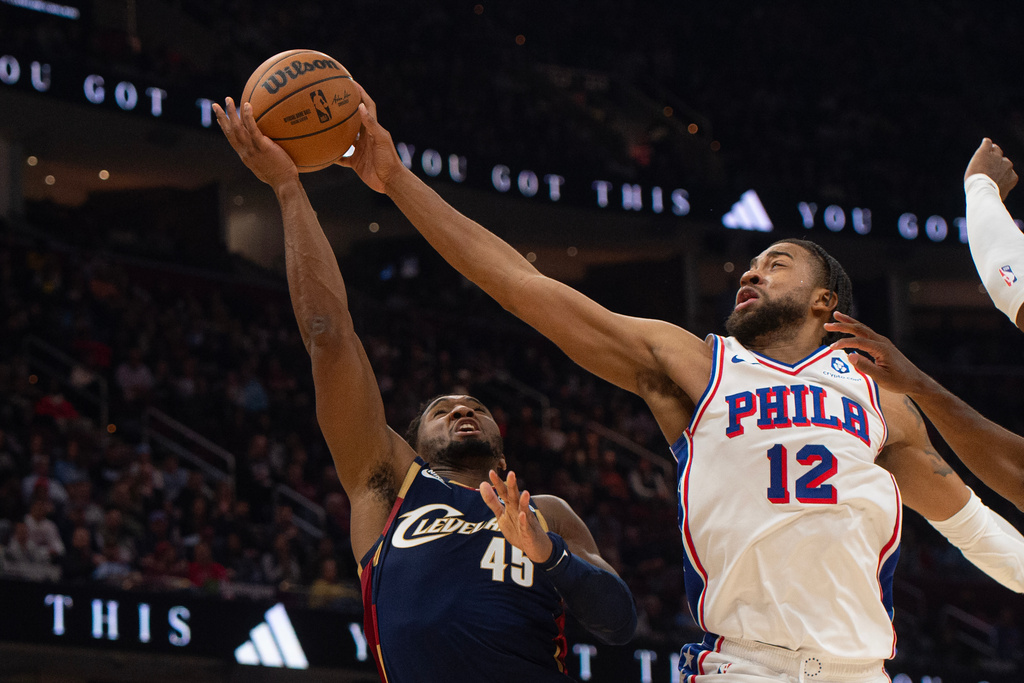 Cleveland Cavaliers' Donovan Mitchell (45) is fouled by Philadelphia 76ers' Trendon Watford (12) during the first half of an NBA basketball game in Cleveland, Wednesday, Nov. 5, 2025. (AP Photo/Phil Long)