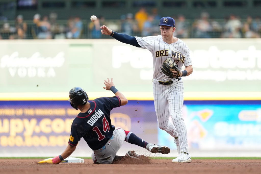 Milwaukee Brewers' Cooper Pratt, right, turns a double play after forcing out Atlanta Braves' Mauricio Dubón (14) at second during the fourth inning of a baseball game Saturday, Aug. 22, 2026, in Milwaukee. (AP Photo/Aaron Gash)