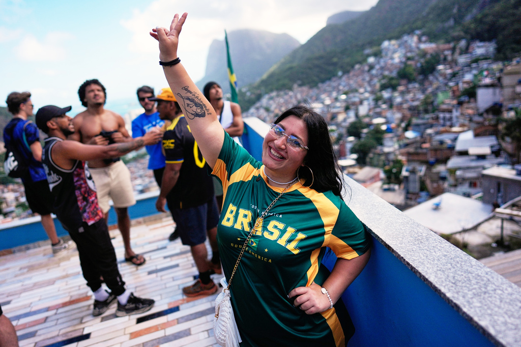 Italian tourist Edda Di Dato, wearing a Brazil's jersey, strikes a pose at a terrace in the Rocinha favela in Rio de Janeiro, on Sept. 2, 2026. (AP Photo/Silvia Izquierdo)