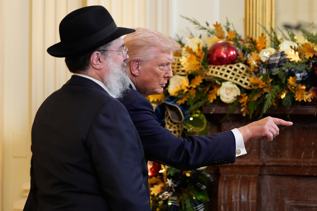 FILE - President Donald Trump gestures during a Hanukkah reception in the East Room of the White House, Dec. 16, 2025, in Washington, as Rabbi Levi Shemtov watches. (AP Photo/Alex Brandon, File)