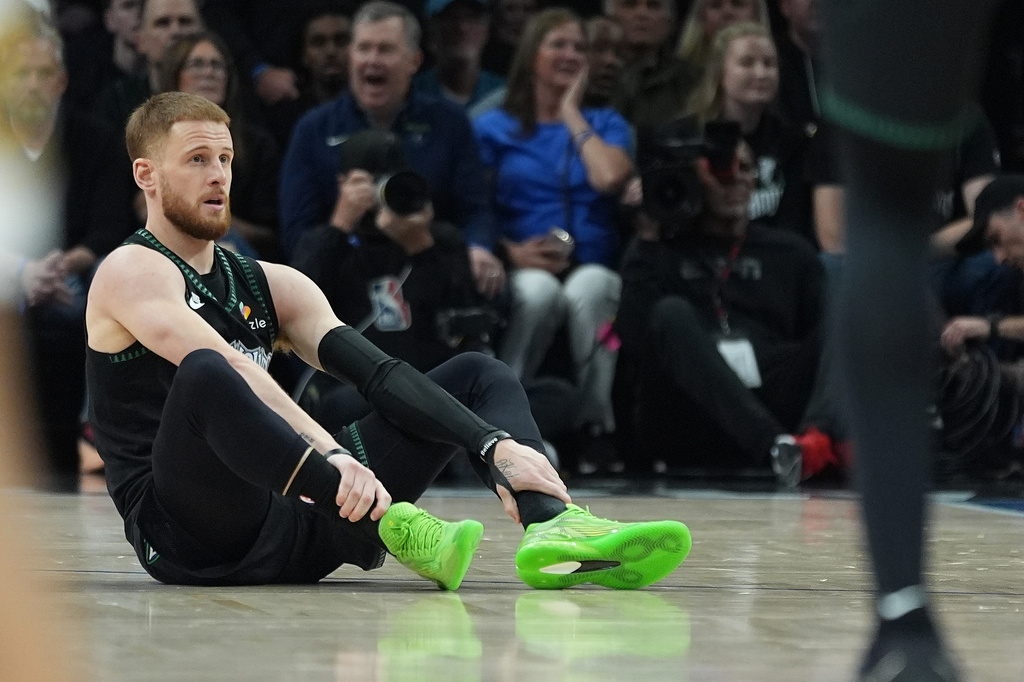 Minnesota Timberwolves guard Donte DiVincenzo (0) sits on the court after sustaining an injury during the first half of Game 4 of a first-round NBA basketball playoff series against the Denver Nuggets, Saturday, April 25, 2026, in Minneapolis. (AP Photo/Abbie Parr)