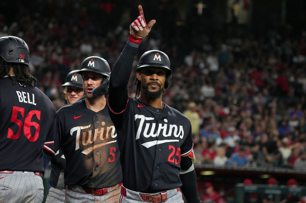 Minnesota Twins' Byron Buxton (25) celebrates after hitting a grand slam with teammates Josh Bell (56) and Ryan Kreidler (5) in the fifth inning of a baseball game against Arizona Diamondbacks Saturday, June 20, 2026, in Phoenix. (AP Photo/Darryl Webb)